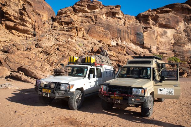 Zwei Landcruiser vor roter Felslandschaft